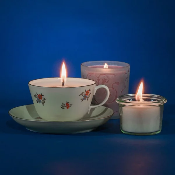 Photo de 3 bougies naturelles dans une tasse et des bougeoirs
